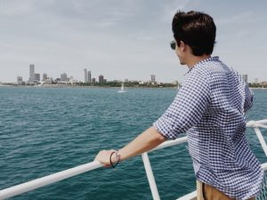 A man looking at a city skyline, waterfront, harbor.