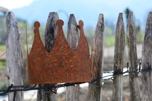 A rustic crown on a wooden fence.