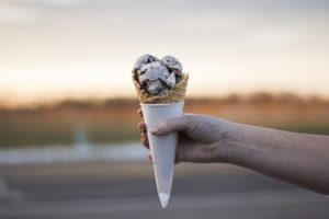 An ice cream cone being offered.