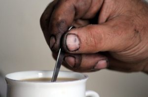 Drinking coffee with someone who has dirty hands and fingernails.