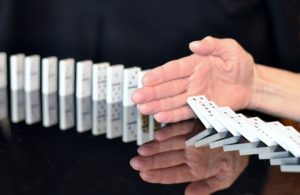 Limiting a row of dominoes from all falling