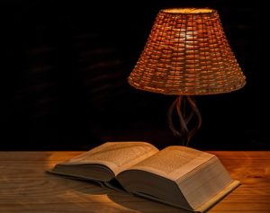 Reading by the light of a table lamp.