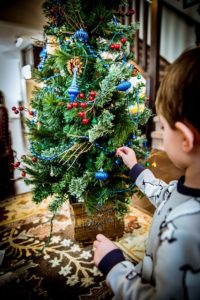 A child decorating a Christmas tree.