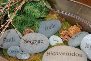 Prayer rocks with one word on each: faith, rejoice, hope, courage, truth, bienvenidos (welcome in spanish), love, and joy.
