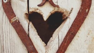 A heart shaped opening in a wooden door.