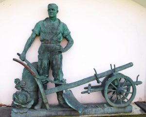 Statue of a farmer and a plow.