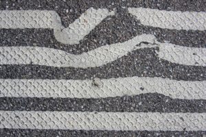 Parallel Lines on asphalt that are increasingly less distorted. 