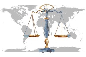 The scales of justice set before a map of the world.