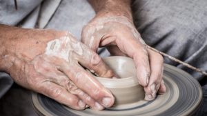 A potter shaping clay on a potter's wheel.