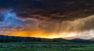 An array of clouds, from blue skies, sunlight, to dark and stormy over Yellowstone Park.