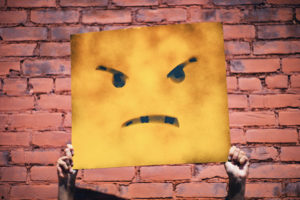A cardboard face displaying anger but not showing the real person's face.