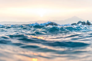 A water level photo of a restless sea calming into peace.