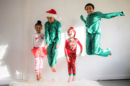 Children jumping for joy in their Christmas pajamas.