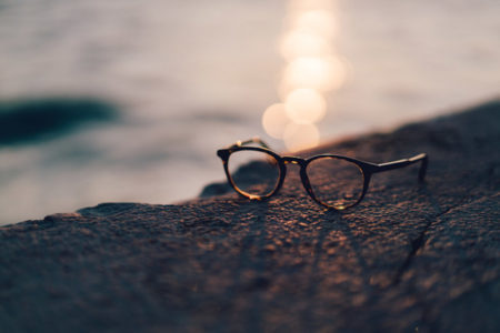 A pair of glasses with a sunset in the background.