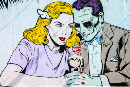 Graffiti of a woman sharing a milkshake with a zombie.