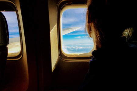 A woman looking out of an airplane window.