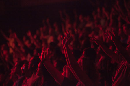 Many hands raised in worship.