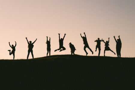 Silhouettes of people jumping in the air.