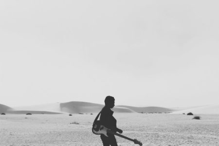 The silhouette of a man with a guitar.