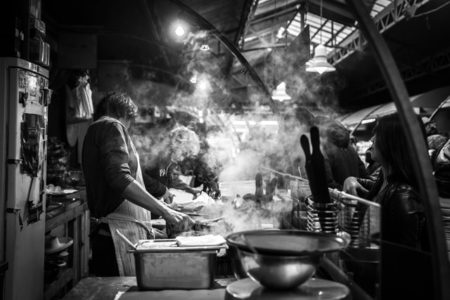 A man cooking in a public market.